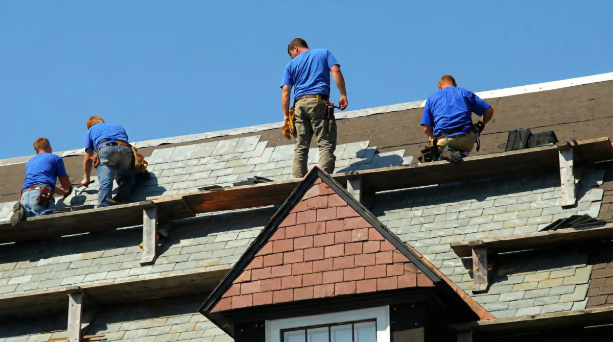 Roof replacement in progress with a team of professional contractors installing new shingles on a residential home in Cincinnati, OH